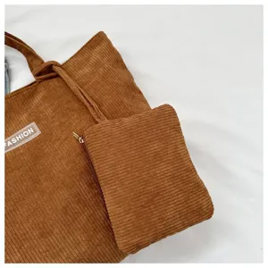 Primer plano de un bolso tote de pana marrón con un pequeño estuche con cremallera