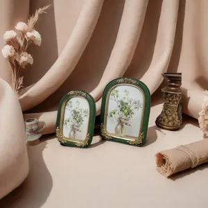 Detailed view of French vintage green resin photo frames with elegant gold floral relief