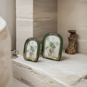French vintage green resin picture frames with gold floral accents on stone