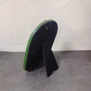 Back view of a retro green resin picture frame featuring a stand and dual metal hanging hooks