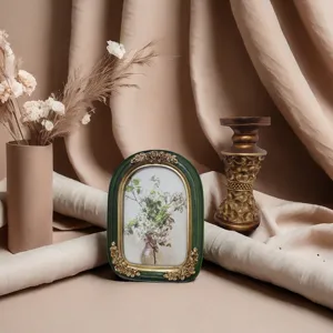 Close-up of a vintage French-style resin photo frame with green and gold floral relief