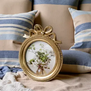Close-up of a vintage gold embossed resin picture frame with a ribbon bow detail