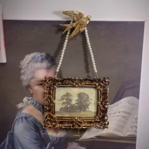 Vintage European style gold photo frame with swallow hook and pearl chain hanging decor.