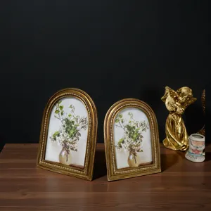 Vintage arched gold photo frames with floral art shown in an elegant home setting