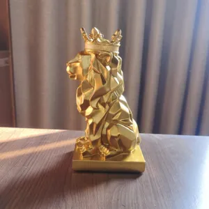 Close-up detail of the golden geometric lion crown figurine for modern desktop decor.