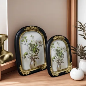 Detail of vintage French resin photo frames with elegant gold floral relief carvings.