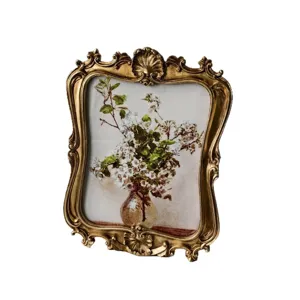 Vintage gold picture frame with floral art print, elegant ornate desktop decor for home.