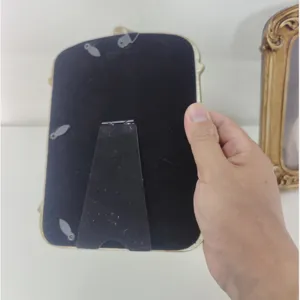 Detailed back view of an ornate European style resin photo frame with black velvet and stand