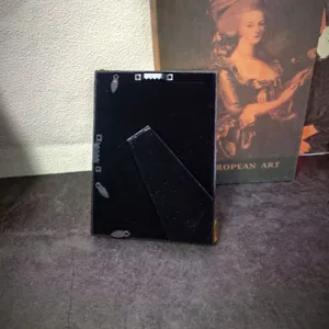 Detail showing the sturdy back stand and hanging hooks of the vintage photo frame.