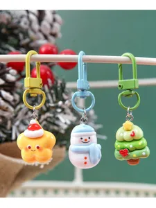 Detailed view of three resin Christmas keychains including a star, snowman, and tree