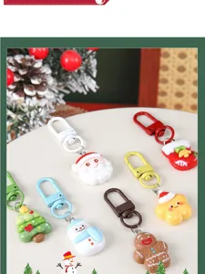 Close-up of various Christmas keychains like Santa and tree on a festive display surface.