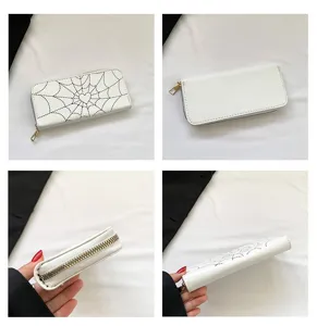 Detail view of white long wallet with spiderweb print and heart stitching detail