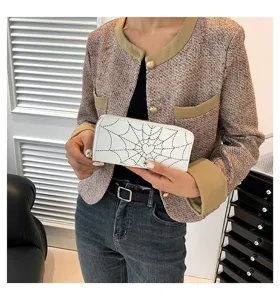 Detailed view of women's white long zipper wallet with black spiderweb and heart print