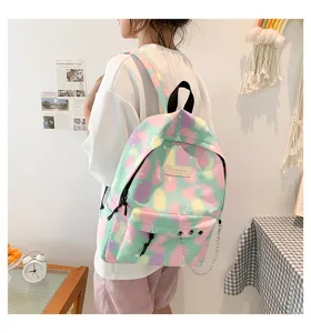 Stylish pastel canvas backpack for school girls with chain detail shown on a model