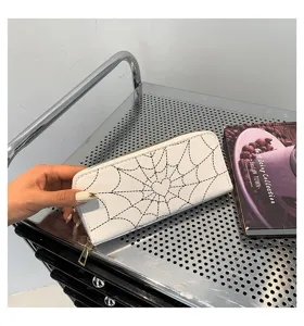 Detailed view of women's long white wallet featuring a black heart spiderweb print.