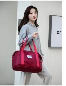 Modelo femenina lleva un gran bolso de viaje granate al aire libre para deporte y gym