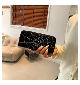 Detailed view of a long black wallet with a white spider web and heart print design