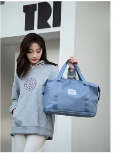 Detalle de una bolsa de deporte azul con compartimento húmedo y asas suaves para mujer.