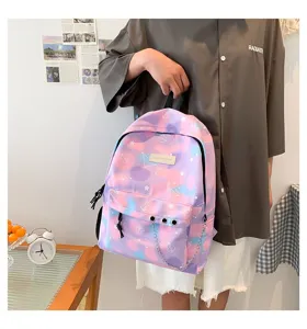 Model holding a vibrant purple tie-dye canvas backpack with metal chain detail.