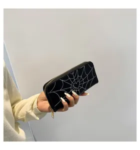 Detailed view of the white spiderweb stitching on a black long zip-around wallet.