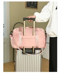Gran bolsa de viaje rosa con funda para equipaje mostrada sobre maleta plateada.