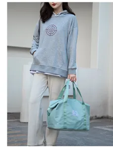 Modelo con una bolsa de viaje verde menta de gran capacidad para gimnasio y yoga