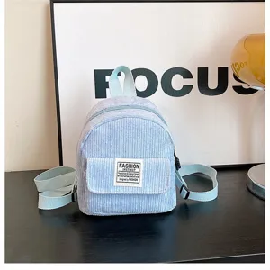 Detailed view of a light blue corduroy mini backpack featuring a stylish fashion patch