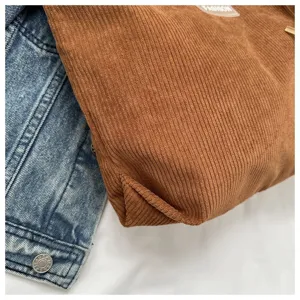 Primer plano del bolso tote de pana marrón que muestra la textura y el pliegue