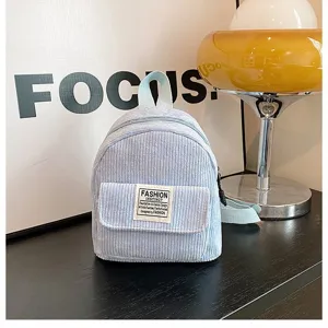 Detailed view of stylish light blue corduroy mini backpack featuring unique fashion patch