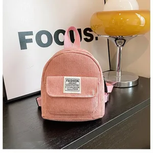 Close-up of pink corduroy mini backpack with fashion patch for casual outdoor travel