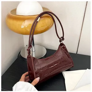 Detailed shot of a burgundy crocodile pattern underarm bag in a vintage room setting.