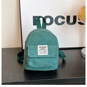 Stylish green corduroy mini backpack for women shown in a detailed lifestyle shot