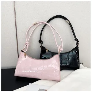 Detailed view of stylish pink and black glossy stone-textured underarm bags for women.