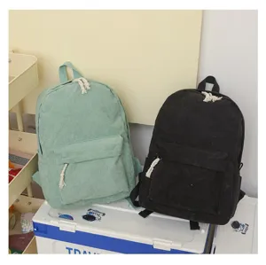Primer plano de mochilas de pana verdes y negras con tiradores de cuerda en detalle