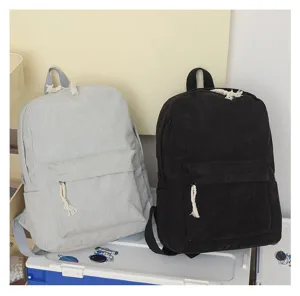 Vista detallada de mochilas de pana en gris y negro con tiradores de cremallera de cuerda