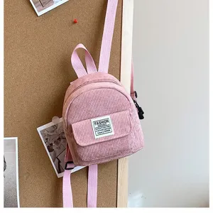 Mini pink corduroy backpack with adjustable straps and front pocket detail