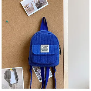 Macro view of blue corduroy texture and fashion label on a stylish mini backpack.