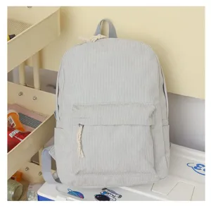 Vista detallada de la mochila de pana gris claro con bolsillo delantero y textura
