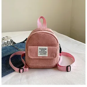 Detailed view of a pink corduroy mini backpack featuring a decorative fashion patch