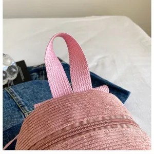 Close-up detail of the pink corduroy fabric and sturdy handle of a casual backpack