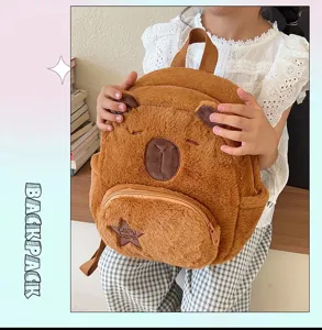 Simpatico zaino di peluche Capybara marrone tenuto da un bambino in un interno accogliente