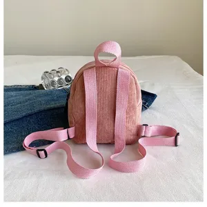 Back view of a pink corduroy mini backpack showing adjustable straps on white background