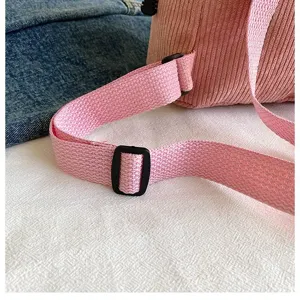 Detailed close-up showing the pink corduroy material and adjustable nylon straps.