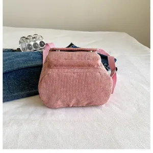 Close-up detail of the pink corduroy small backpack showing durable bottom construction.