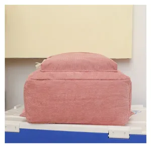 Vista inferior de mochila de pana rosa mostrando la base y textura de la tela