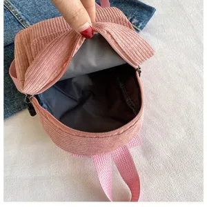 Detailed view showing the gray inner lining of a pink corduroy mini backpack bag