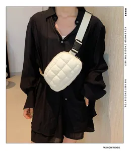 Riñonera acolchada blanca elegante sobre una camisa negra para un look moderno y actual