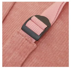 Primer plano de la correa ajustable y la hebilla en la mochila de pana rosa.