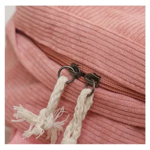 Detalle de cerca de una mochila de pana rosa con cremalleras dobles y tiradores de cuerda