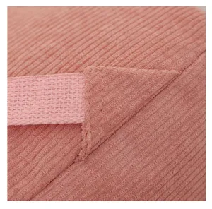 Primer plano de mochila de pana rosa con costuras reforzadas en la correa del hombro.